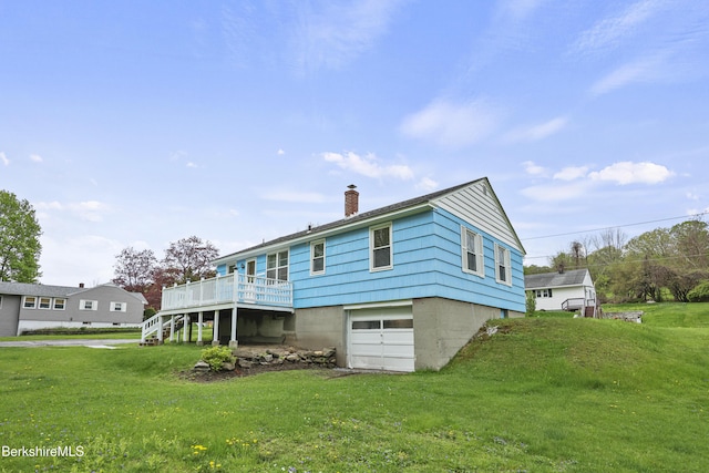 rear view of house featuring an attached garage, a chimney, a deck, a yard, and stairway