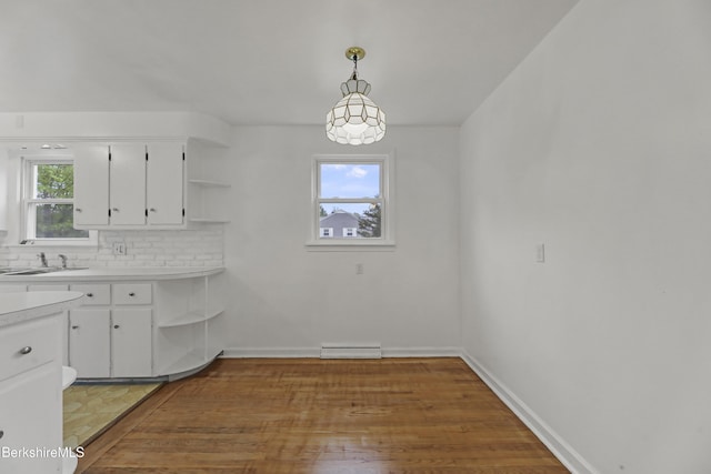 kitchen with open shelves, a sink, white cabinets, and light countertops