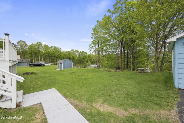 view of green lawn featuring a storage unit and an outdoor structure