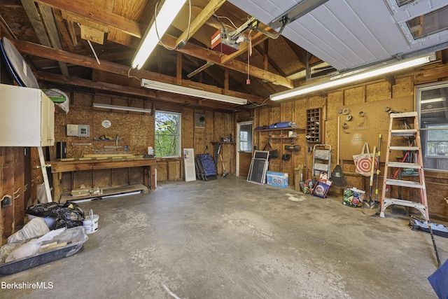 garage with a workshop area and wooden walls