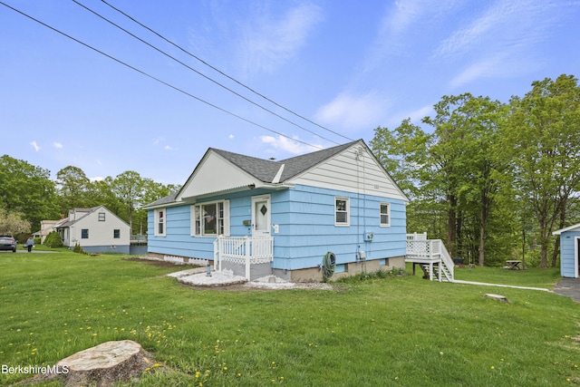 view of front facade with a front yard and roof with shingles