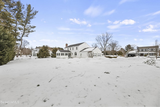 snowy yard featuring a sunroom