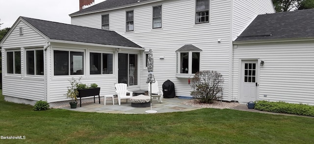 back of house with a patio area, a shingled roof, a sunroom, and a yard