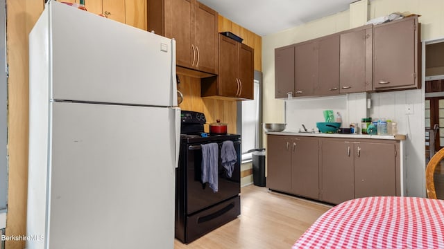 14 Hall St, North Adams, MA 01247 - kitchen featuring freestanding refrigerator, black / electric stove, light wood-style flooring, and light countertops