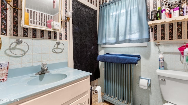 14 Hall St, North Adams, MA 01247 - bathroom with tile walls, radiator, vanity, toilet, and wallpapered walls