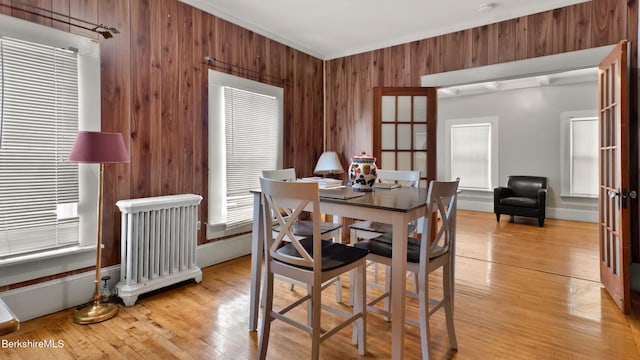 14 Hall St, North Adams, MA 01247 - dining area with radiator heating unit, wood walls, light wood-style flooring, and ornamental molding