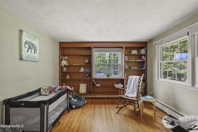 785 E New Lenox Rd, Pittsfield, MA 01201 - sitting room with a baseboard radiator, wallpapered walls, hardwood / wood-style flooring, healthy amount of natural light, and built in shelves