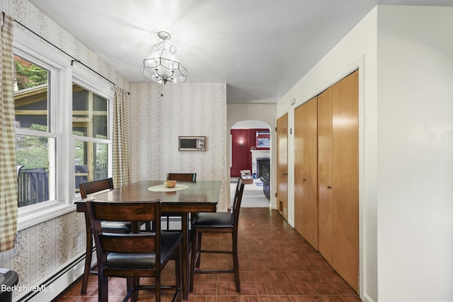 785 E New Lenox Rd, Pittsfield, MA 01201 - dining space with wallpapered walls, a baseboard heating unit, arched walkways, a chandelier, and a fireplace