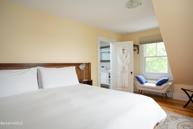 bedroom featuring a sink and wood finished floors