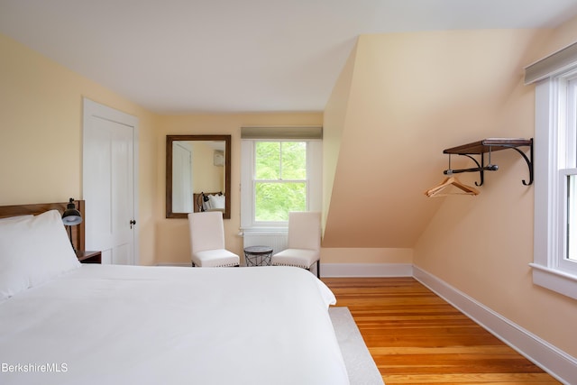 bedroom featuring light wood finished floors and baseboards