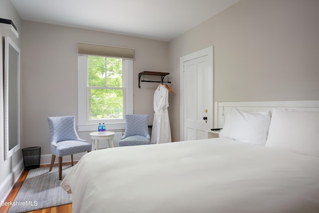 bedroom with baseboards and wood finished floors