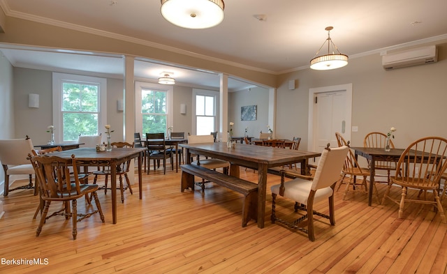 dining room with an AC wall unit, light wood finished floors, and crown molding