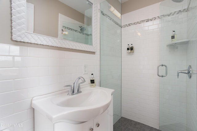 bathroom featuring tile walls, a shower stall, and vanity