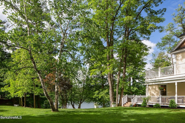 view of yard featuring a balcony and a wooden deck