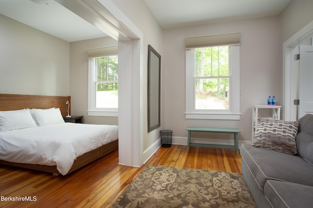 bedroom with wood-type flooring and baseboards