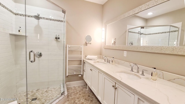 full bath with double vanity, radiator heating unit, a sink, and a shower stall