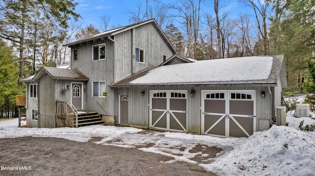 snow covered garage featuring cooling unit