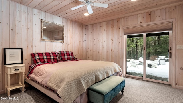 bedroom with carpet floors, wood ceiling, wooden walls, and access to outside