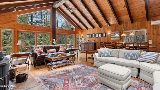 living area with beam ceiling, wood finished floors, wood walls, and a wall mounted AC