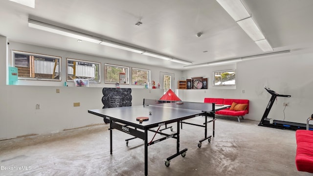 recreation room with unfinished concrete flooring