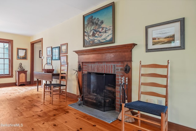 sitting room with a fireplace and hardwood / wood-style floors