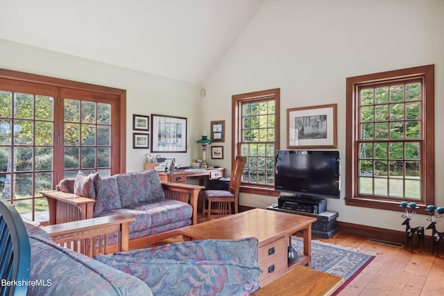 living room featuring light hardwood / wood-style flooring and high vaulted ceiling