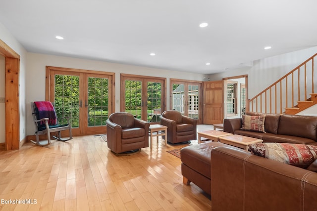 living room with light hardwood / wood-style floors, a wealth of natural light, and french doors