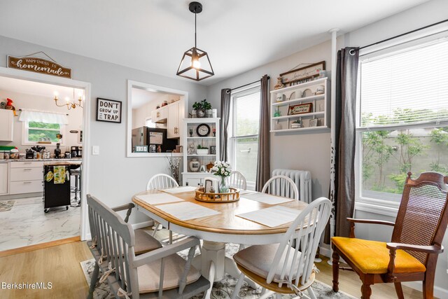 24 Front St Unit 22-24, Williamstown, MA 01267 - dining room with light wood-type flooring, radiator, a chandelier, and baseboards