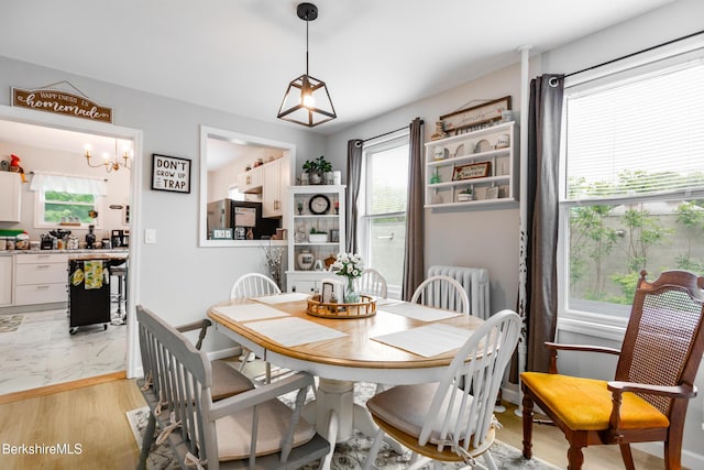 24 Front St Unit 22-24, Williamstown, MA 01267 - dining room with light wood-type flooring, radiator, a chandelier, and baseboards