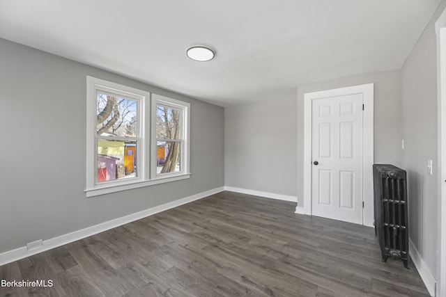 empty room featuring dark wood-style floors and baseboards