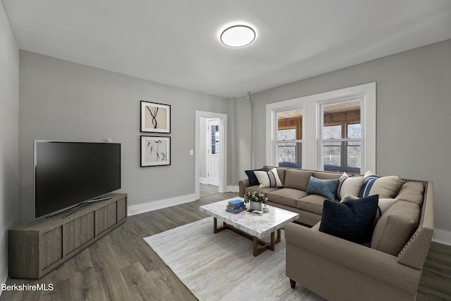 living room featuring baseboards and dark wood-style flooring