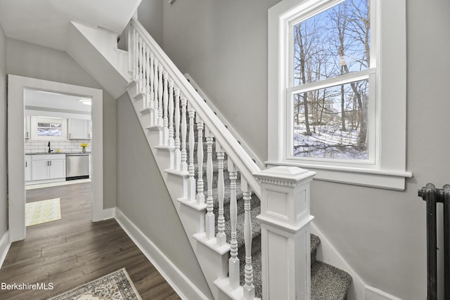 staircase with baseboards and wood finished floors