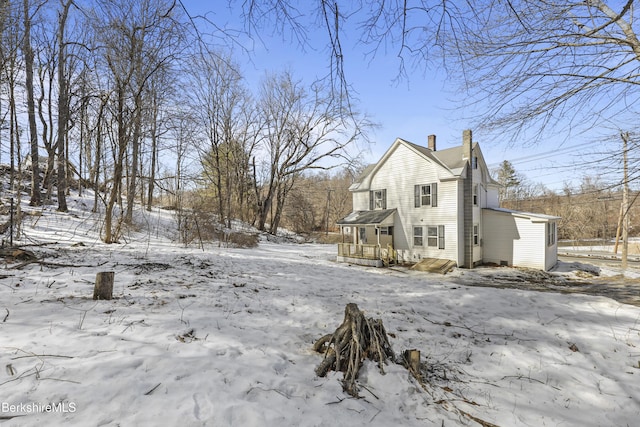 view of snow covered exterior with a chimney