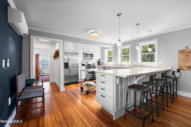 49 S St, Great Barrington, MA 01230 - kitchen with appliances with stainless steel finishes, a peninsula, white cabinetry, a wall mounted AC, and ornamental molding