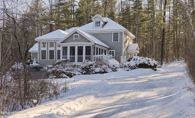 snow covered property featuring a sunroom