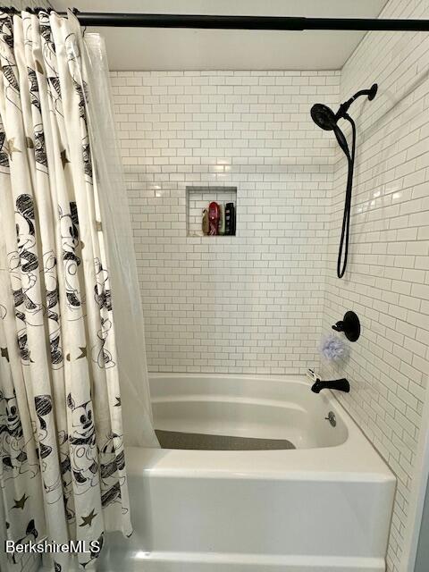 bathroom with shower / bathtub combination with curtain
