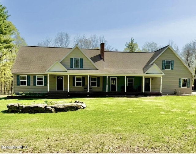 view of front facade with covered porch, a chimney, and a front lawn