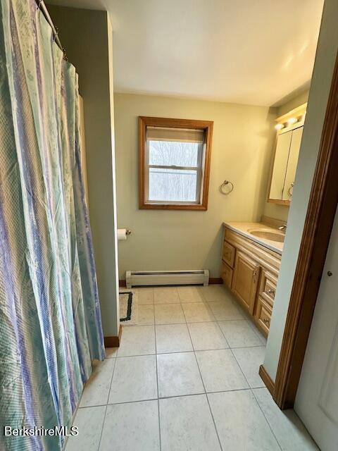 bathroom featuring baseboards, a baseboard radiator, tile patterned floors, and vanity