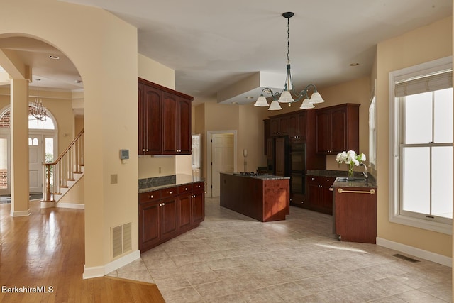 kitchen with sink, a center island, pendant lighting, and a chandelier