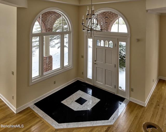 entrance foyer with hardwood / wood-style floors and a chandelier