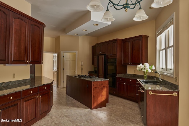 kitchen with sink, dark stone counters, hanging light fixtures, a center island, and stainless steel appliances