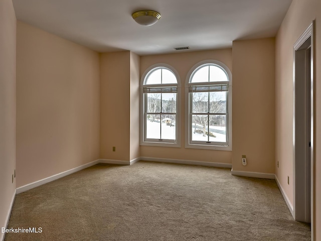 unfurnished room featuring light carpet