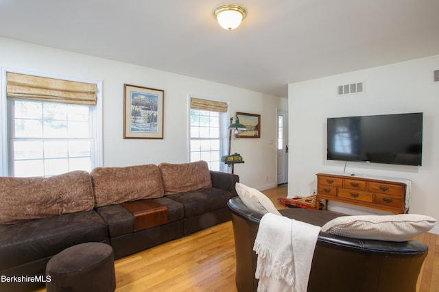 living area with light wood-style flooring and visible vents