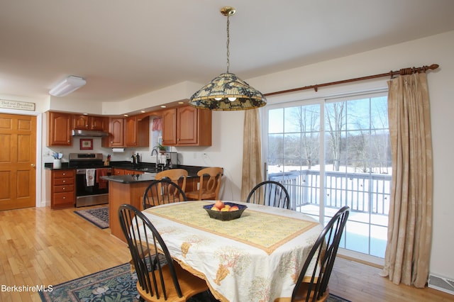 dining area with light wood-style floors and visible vents