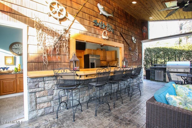 view of patio featuring grilling area, an outdoor bar, and ceiling fan