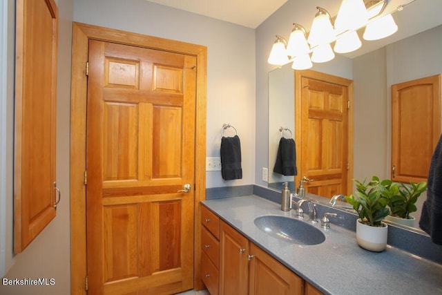 bathroom with vanity and a notable chandelier