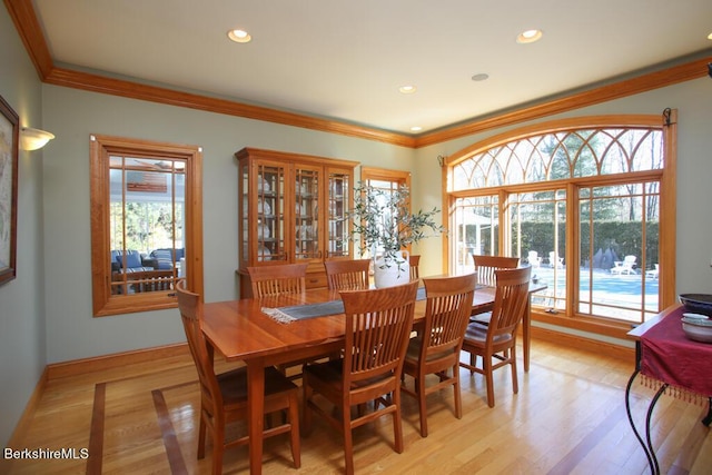 dining room featuring a wealth of natural light, crown molding, and light hardwood / wood-style floors