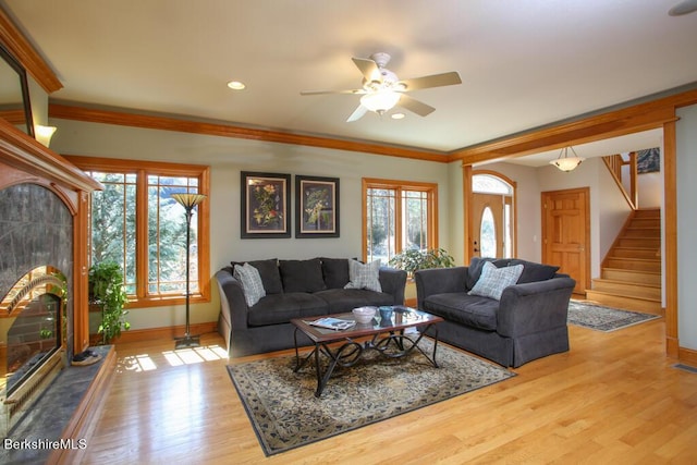 living room featuring ceiling fan, light wood-type flooring, and ornamental molding