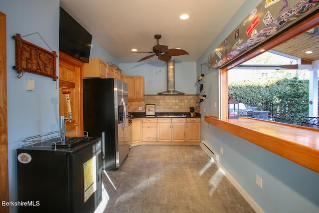 kitchen featuring decorative backsplash, appliances with stainless steel finishes, ceiling fan, wall chimney range hood, and a baseboard radiator