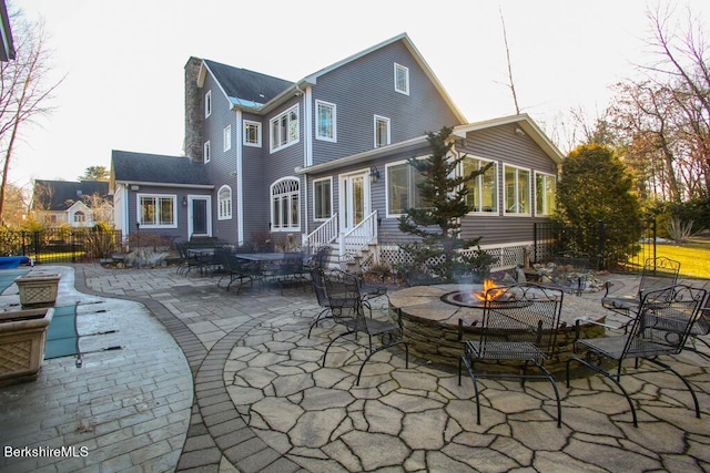 rear view of house with a patio area and an outdoor fire pit